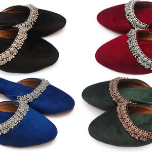 May include: Four pairs of velvet slippers with jeweled embellishments. The slippers are in black, red, blue, and green.