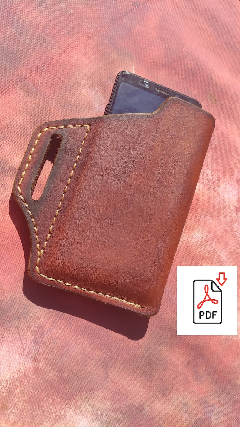 Pode incluir: Uma capa de telefone de couro marrom com uma borda costurada e um recorte para um telefone. A capa tem um la&ccedil;o na parte superior para prender a um cinto.