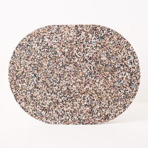 Peut inclure: Un set de table de forme ovale pr&eacute;sentant un motif dense et tachet&eacute; compos&eacute; de minuscules &eacute;clats multicolores dans des tons de brun, noir, blanc, avec des touches occasionnelles de bleu et de rose, cr&eacute;ant un aspect textur&eacute; en mosa&iuml;que.