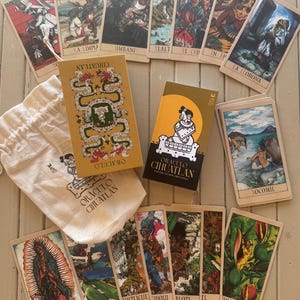 May include: A deck of Oraculo Cihuatlan oracle cards featuring illustrated cards with various figures and scenes, a mustard yellow box with a green serpent design, a black box with a yellow sun and figure, and a cream-colored drawstring pouch.