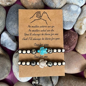 Puede incluir: Dos pulseras de amistad a juego con cordón negro y cuentas blancas y grises. Cada pulsera tiene un pequeño dije de tortuga. La tarjeta dice "No importa a dónde vayamos, No importa lo que hagamos, Siempre estarás ahí para mí Y siempre estaré ahí para ti. Uno para ti Uno para mí."