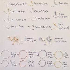 K&ouml;nnte beinhalten: Eine Auswahl an Ohrring-Komponenten, darunter Haken, &Ouml;sen und Creolen, in verschiedenen Metallen und Ausf&uuml;hrungen. Textetiketten kennzeichnen Typen wie "Sterling Silver 925", "Gold Plated Hooks" und "Silver Hoops 25mm". Das Bild zeigt verschiedene Stile und Gr&ouml;&szlig;en.