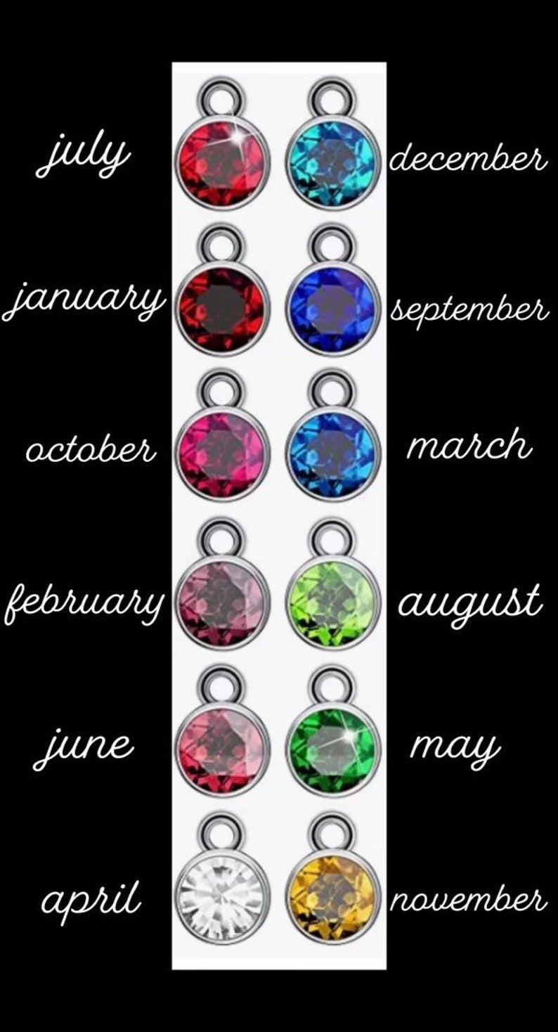 May include: Twelve round charms with different coloured gemstones, each charm has a silver loop at the top. The charms are labelled with the months of the year: January, February, March, April, May, June, July, August, September, October, November, and December.