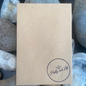 May include: A brown paper envelope with a circular logo that says "Holly and Lili" in a cursive font.