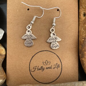 May include: Silver angel earrings with the inscription "Made for an Angel" on a brown card with the text "Holly and Lili" in a circle.