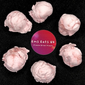 May include: Six pink freeze-dried ice cream scoops on a black background. The label reads "Ems Eats UK Freeze Dried Treats".