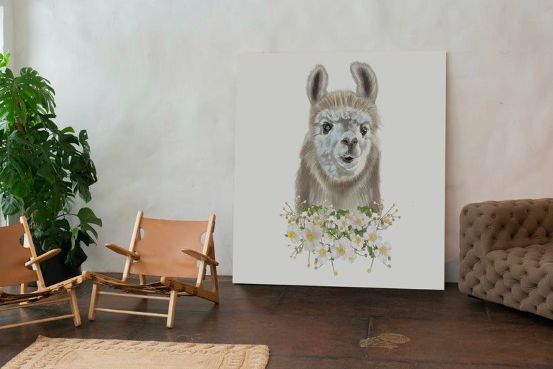 May include: A white canvas print featuring a close-up portrait of a llama with white flowers around its neck. The llama has brown fur and a white face. The background is white.