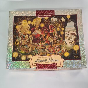 May include: A Waddingtons Super De luxe 1000 piece Limited Edition double-sided puzzle. The box features a festive Christmas scene with Santa Claus, elves, and a snowy landscape. The box has a silver glitter border.