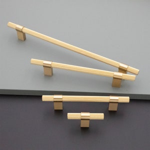 May include: Four gold cabinet pulls with a textured finish. The pulls are in different sizes, with the largest pull being at the top of the image and the smallest pull at the bottom.