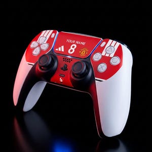 May include: A white and red wireless gaming controller featuring a custom design with the text YOUR NAME, the number 8, and a Manchester United football club logo. The controller includes black analog sticks, a directional pad, and action buttons.