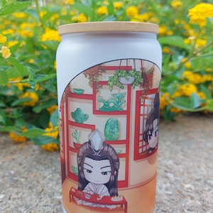 Könnte beinhalten: Ein weißer Becher mit einem bambusfarbenen Deckel. Der Becher zeigt eine Cartoon-Illustration eines Charakters in einem Raum mit Regalen, Pflanzen und Jade-Ornamenten. Der Hintergrund ist verschwommen mit gelben Blumen und grünem Laub.