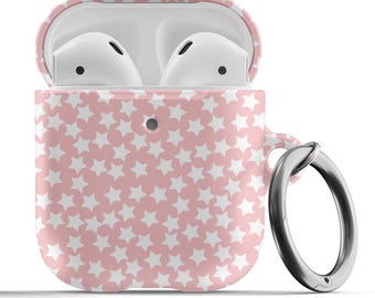 Pode incluir: Uma capa rosa para Airpods com um padrão de estrelas brancas e um anel prateado.