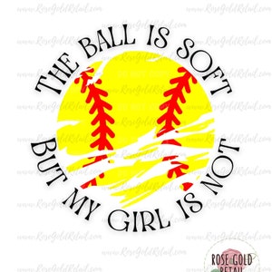 Può includere: Una palla da softball gialla con cuciture rosse e un aspetto usurato. Il testo "The ball is soft but my girl is not" circonda la palla.