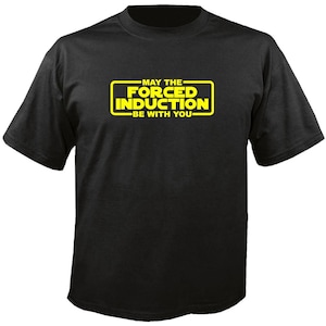 May include: Black t-shirt with a yellow rectangular graphic. The graphic reads "MAY THE FORCED INDUCTION BE WITH YOU" in a stylized font. The shirt is a short-sleeved crew neck.