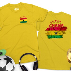 May include: Two yellow t-shirts with a Ghanaian flag design. One shirt has a small flag on the left chest and the other has a larger flag with the word "GHANA" on the back.