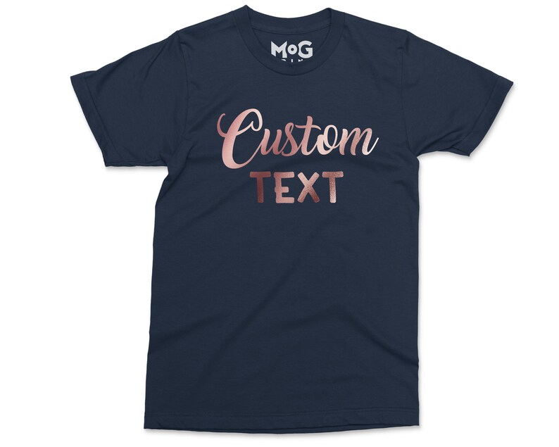 May include: A navy blue t-shirt with the words "Custom Text" in rose gold foil lettering.