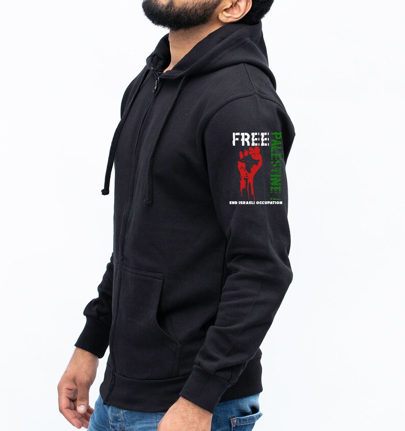 Pode incluir: Casaco de moletom preto com z&iacute;per e capuz, um punho vermelho e as palavras "Free Palestine" e "End Israeli Occupation" impressas na manga.