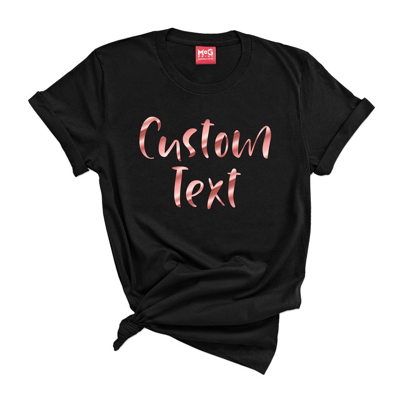 May include: Black t-shirt with the text "Custom Text" in rose gold foil lettering.