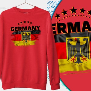 May include: Red sweatshirt with a black and yellow German flag design and the word "GERMANY" printed on the front. Five black stars are above the word "GERMANY".