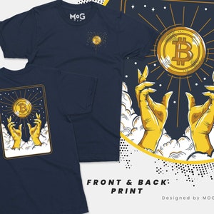 Könnte beinhalten: Ein marineblaues T-Shirt mit einem Grafikdruck von zwei gelben Händen, die nach einem leuchtenden goldenen Bitcoin-Symbol greifen. Das Design zeigt weiße Wolken und einen Sternenhimmel, mit einer kleineren Version der Bitcoin-Grafik auf der Brust.