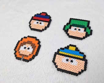 May include: Four colorful pixel art characters from the animated television show South Park. The characters are Kenny, Stan, Kyle, and Cartman. Each character is made of small plastic beads.