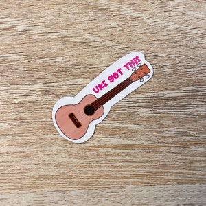May include: A pink ukulele with the text "UKE GOT THIS" in pink lettering.