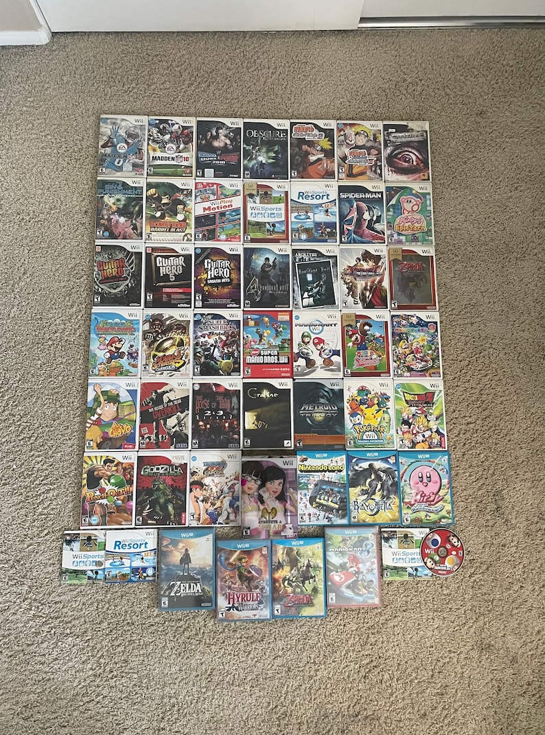 May include: A collection of video game cartridges for the Nintendo Wii console. The cartridges are arranged in rows and columns on a carpeted surface. The cartridges are a mix of different genres, including action, adventure, sports, and racing. Some of the titles include "Madden 10", "Guitar Hero", "Zelda", and "Super Mario Bros. Wii".