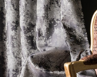 May include: A close-up of a grey and white patterned fabric draped over a chair with a gold frame. The fabric has a textured, distressed look.