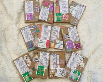 May include: An overhead shot of several wrapped books, each with handwritten notes and decorative stickers. The books are wrapped in brown paper and tied with twine or ribbon. The stickers include the words "To", "Read", and "Boo!"