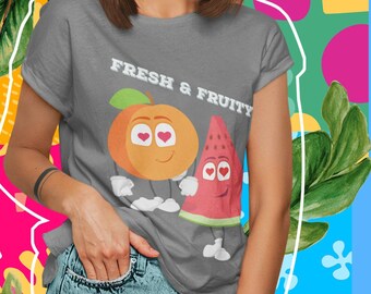 Könnte beinhalten: Ein graues T-Shirt mit einem Pfirsich- und Wassermelonen-Motiv und dem Text "Fresh & Fruity". Der Pfirsich und die Wassermelone haben Comic-Augen und halten sich an den Händen.