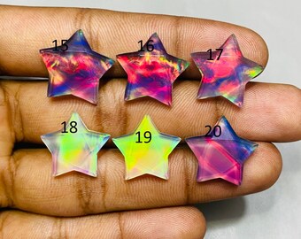 May include: Six star-shaped gemstones with iridescent colors, including pink, purple, green, and yellow. Each star is numbered from 15 to 20. The gemstones are displayed on a light-colored surface.