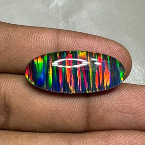 May include: A vibrant, multi-colored opal gemstone with a striped pattern. The oval-shaped stone has a dark background with flashes of red, green, blue, and yellow.