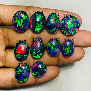 Peut inclure: Dix cabochons ovales en opale noire avec des reflets iris&eacute;s verts, bleus et rouges. Les pierres sont num&eacute;rot&eacute;es de 1038 &agrave; 1047.