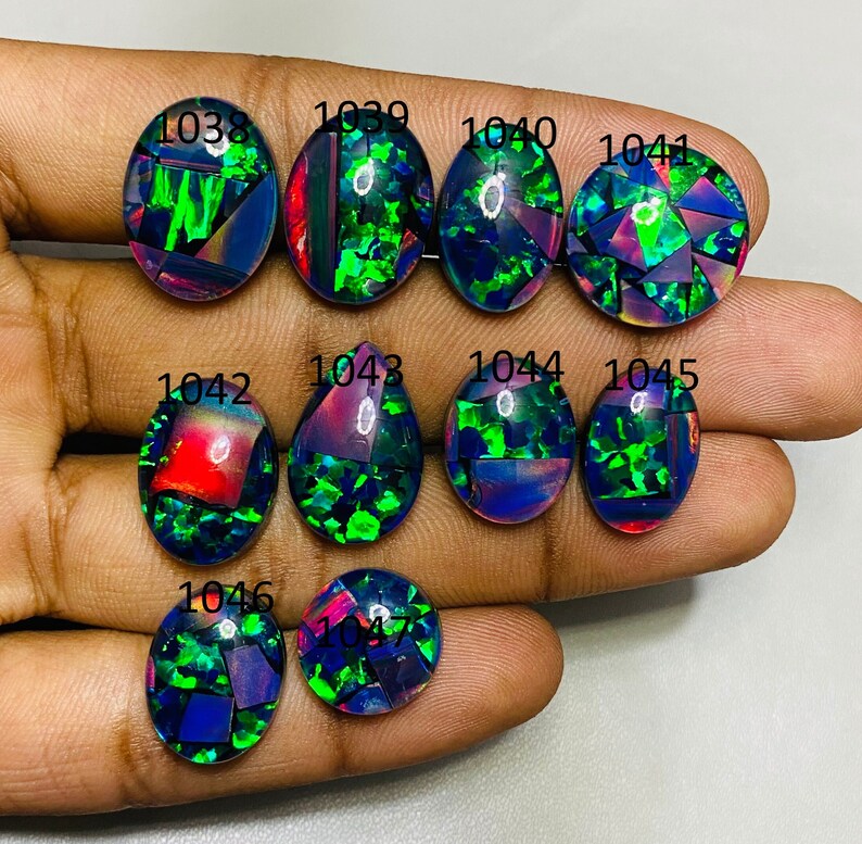 Peut inclure: Dix cabochons ovales en opale noire avec des reflets iris&eacute;s verts, bleus et rouges. Les pierres sont num&eacute;rot&eacute;es de 1038 &agrave; 1047.