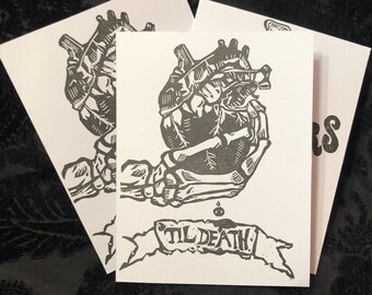 Puede incluir: Una ilustración en blanco y negro de una mano esquelética sosteniendo un corazón con una pancarta que dice "Til Death".