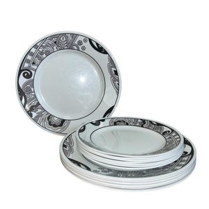 May include: A set of white ceramic plates with black and grey floral designs. The plates are stacked in a pyramid shape.