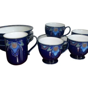 May include: A set of blue and white ceramic teacups and saucers with a floral design. There is also a matching mug and a bowl.