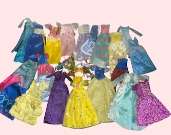 May include: A collection of doll dresses in various colors, including blue, yellow, pink, and purple. The dresses have different styles, some with glitter, lace, and decorative accents. A few masks are also included in the assortment.