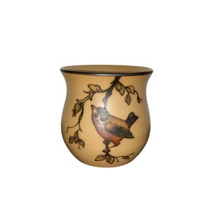 May include: A brown ceramic mug with a painted design of a bird on a branch. The bird is brown, black, and orange.