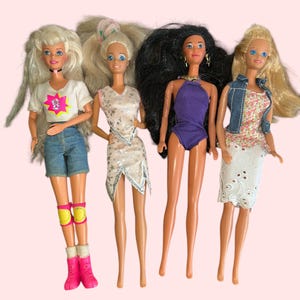 May include: Four Barbie dolls with different hairstyles and outfits. The dolls are wearing a white shirt with a pink graphic, a white and silver dress, a purple swimsuit, and a floral dress with a denim jacket.