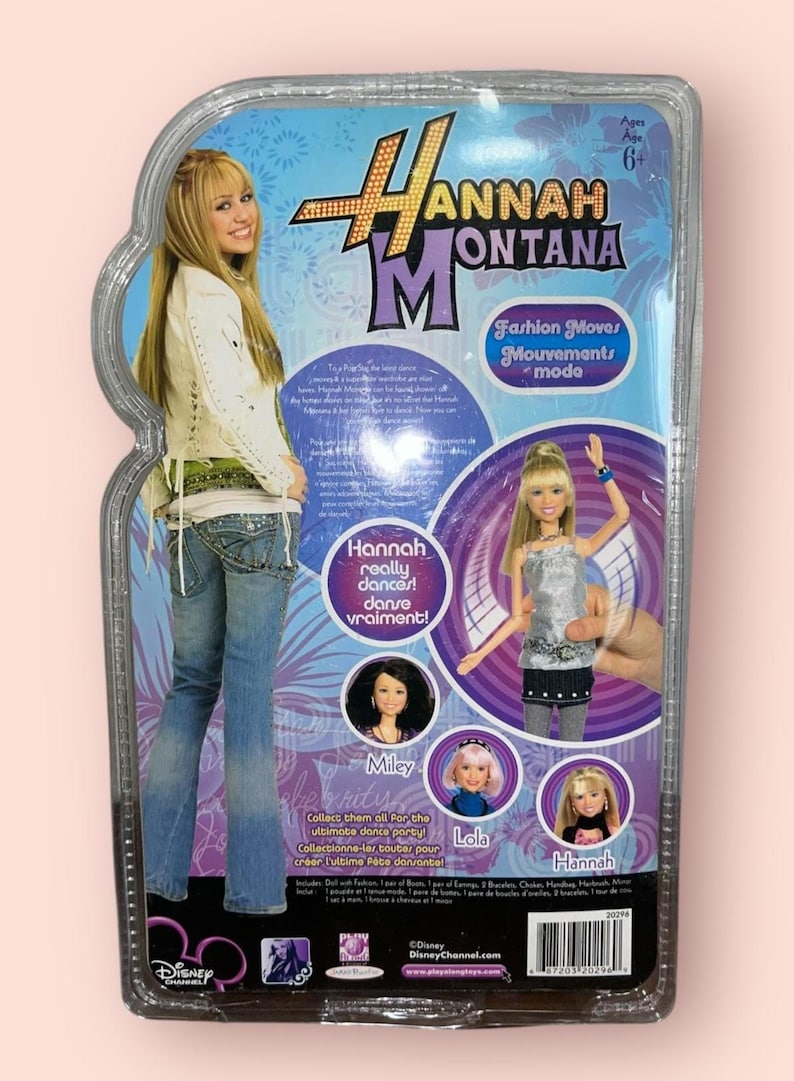 Pu&ograve; includere: Una bambola di Hannah Montana in una confezione di plastica trasparente. La confezione presenta immagini di Hannah Montana, Miley e Lola. Il testo sulla confezione recita "Fashion Moves" e "Hannah really dances!"