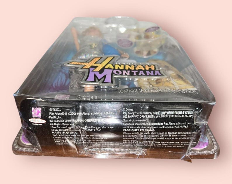 Pu&ograve; includere: Action figure sigillata di Hannah Montana in una confezione di plastica trasparente. La confezione presenta il logo di Hannah Montana in viola e oro. La confezione contiene 16 pezzi. Prodotto da Play Along.