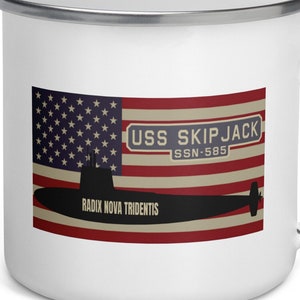 May include: White enamel mug with a graphic of the USS Skipjack submarine, a US flag, and the text "USS SKIPJACK SSN-585 RADIX NOVA TRIDENTIS".