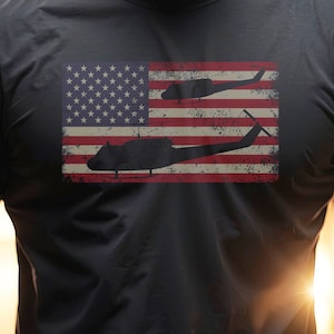 May include: A black t-shirt with a distressed American flag design featuring two silhouette helicopters.