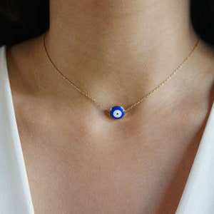 Peut inclure: Un collier en cha&icirc;ne dor&eacute;e avec un pendentif &oelig;il turc bleu et blanc.
