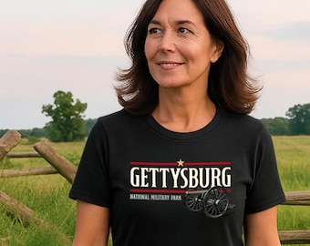 May include: Black t-shirt with the word "GETTYSBURG" in white letters with a red stripe above and below the word. Below the word is "NATIONAL MILITARY PARK" in white. A cannon graphic is below the text.