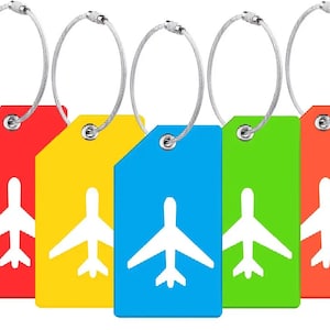 May include: Set of five luggage tags featuring airplane icons. The tags are red, yellow, blue, green and orange. Each tag has a silver metal loop with a wire attached.