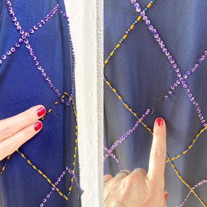 May include: A navy blue sheer fabric with a diamond pattern of purple and gold beads. The fabric has a small hole in the center.