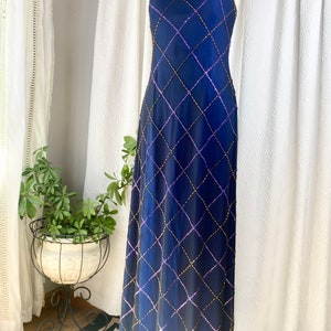 May include: A long, strapless, navy blue gown with a diamond-shaped pattern of sequins in gold and purple.