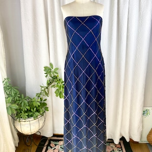 May include: A strapless, floor-length, navy blue gown with a diamond-shaped pattern of gold and purple sequins.